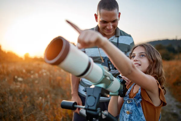 Vater und Tochter beobachten den Himmel mit dem Teleskop. — Stockfoto