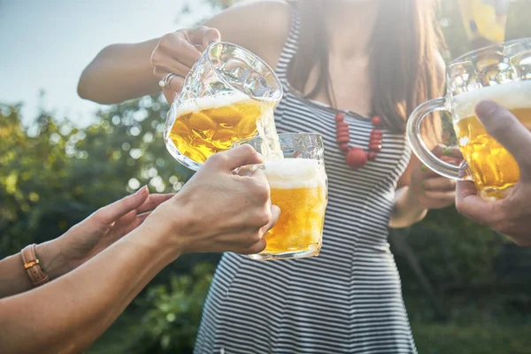 Grupo de jóvenes disfrutando y animando la cerveza al aire libre . — Foto de Stock