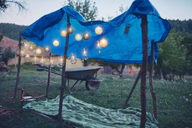 Arka bahçesinde mumlar ve lampionlar olan küçük çocuk çadırı..