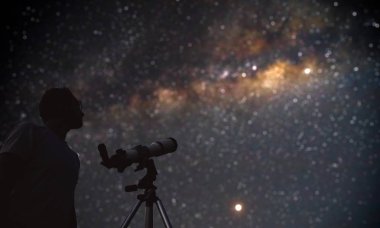 Teleskopla Ay 'ı ve yıldızları izleyen bir astronom. Benim...