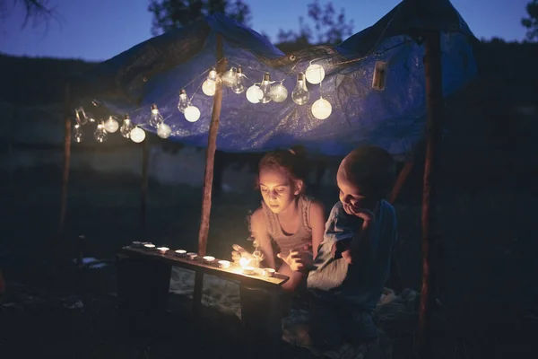 Crianças fazendo uma pequena tenda com velas e lampiões no backya — Fotografia de Stock