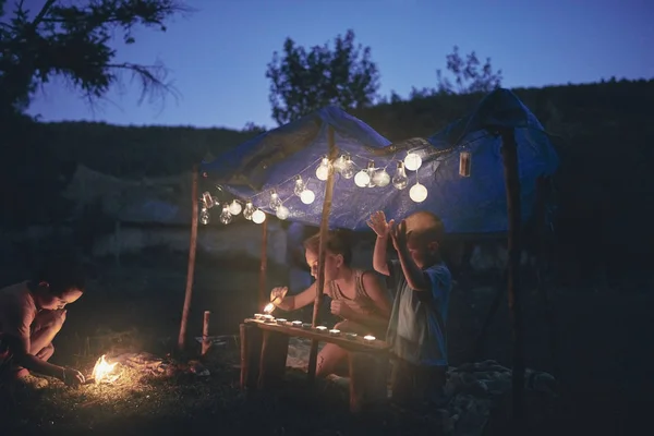 Crianças fazendo uma pequena tenda com velas e lampiões no backya — Fotografia de Stock