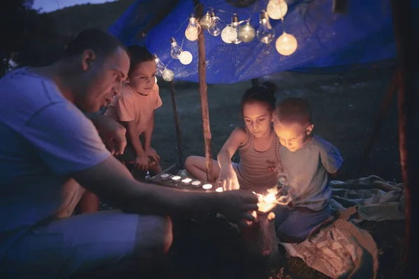 父亲和孩子们在自家后院的帐篷下和蚂蚁玩耍 — 图库照片