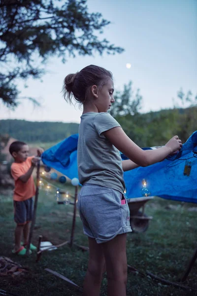 Crianças fazendo uma pequena tenda com velas e lampiões no backya — Fotografia de Stock