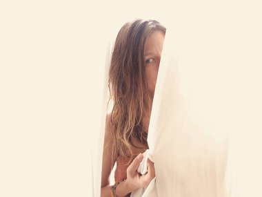 Kadın perdenin arkasında saklanıyor..