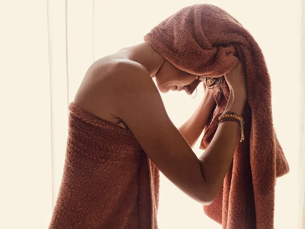 창문 과 커튼 앞에서 수건을 두르고 있는 여자. — 스톡 사진
