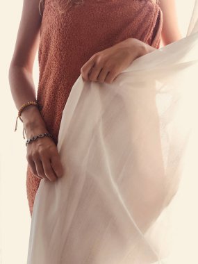 Pencerenin önünde ve perdede havlusu olan kadın..