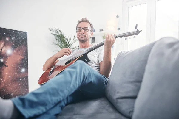 在客厅里弹奏吉他的人. — 图库照片