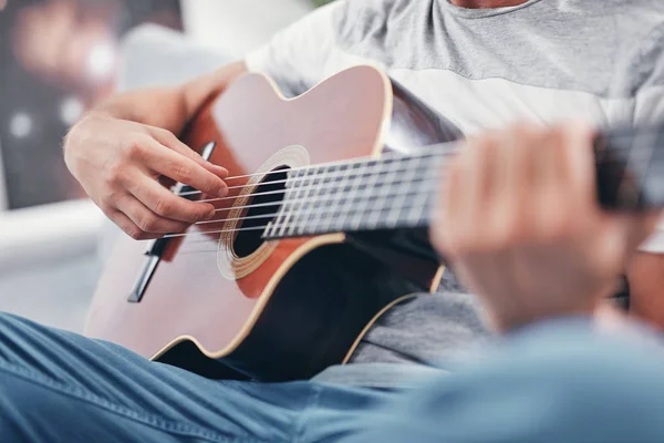 Man spelar akustisk gitarr i vardagsrummet. — Stockfoto