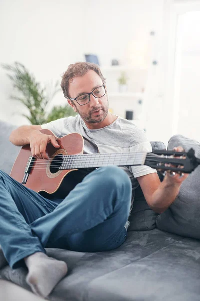 在客厅里弹奏吉他的人. — 图库照片