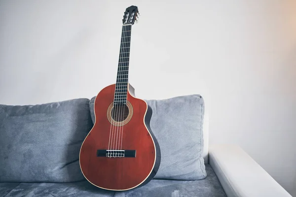 Akustisk gitarr på soffa / soffa i vardagsrummet. — Stockfoto