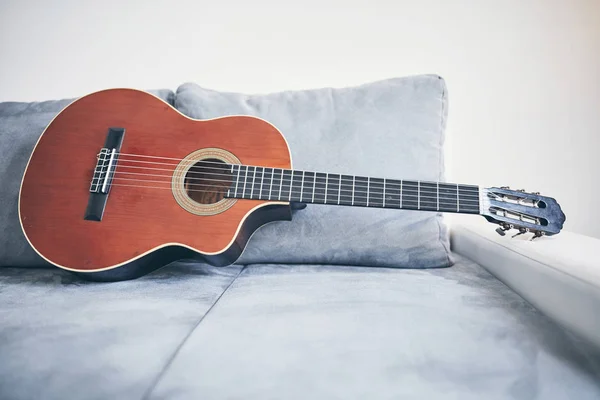 客厅沙发/沙发上的声学吉他. — 图库照片