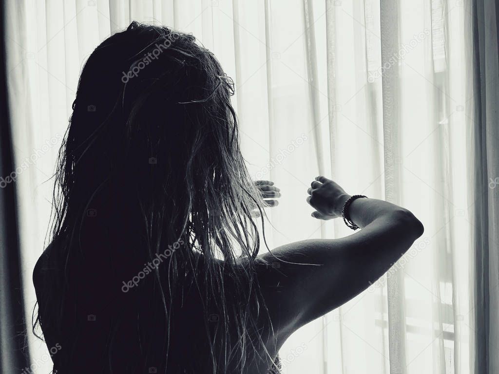 Silhouette of a girl while waking up in the room and holding cur