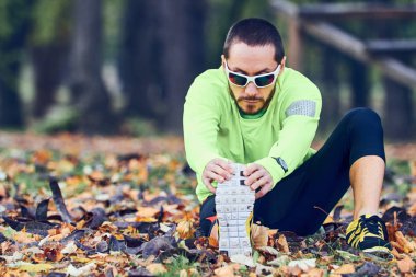 Adam parkta egzersiz yaptıktan sonra geriniyor..