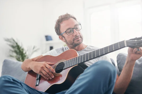 Hombre tocando la guitarra acústica en el salón . —  Fotos de Stock