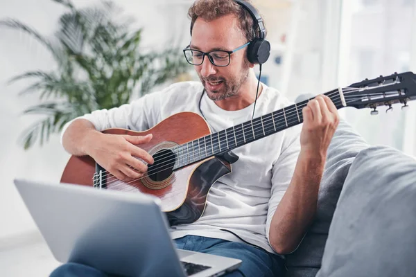 Hombre tocando la guitarra acústica en el salón . —  Fotos de Stock