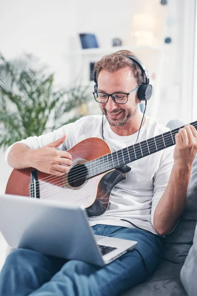 Hombre tocando la guitarra acústica en el salón . —  Fotos de Stock