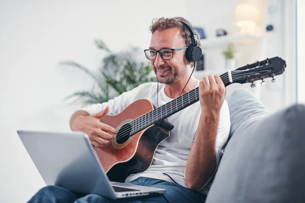 Hombre tocando la guitarra acústica en el salón . —  Fotos de Stock