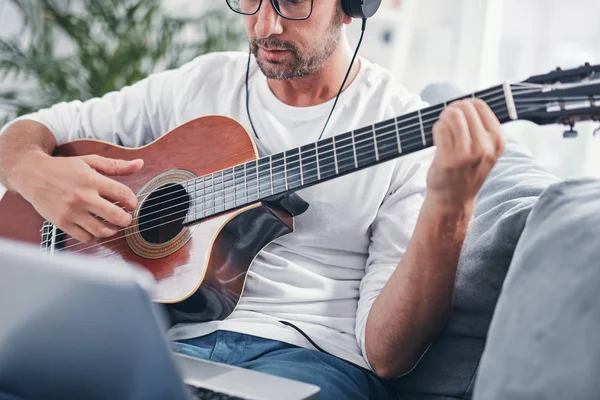 Hombre tocando la guitarra acústica en el salón . —  Fotos de Stock