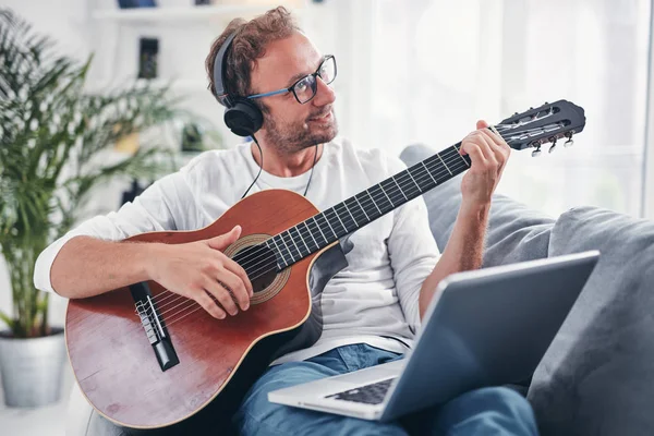 Hombre tocando la guitarra acústica en el salón . —  Fotos de Stock