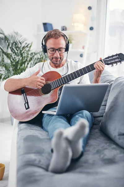 Hombre tocando la guitarra acústica en el salón . —  Fotos de Stock