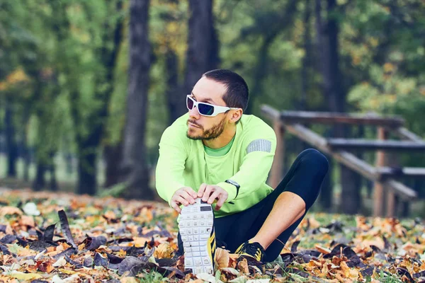 Hombre estirándose después del ejercicio en el parque . — Foto de Stock