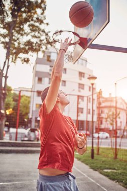 Basketbol sahasında atış yapan bir adam.