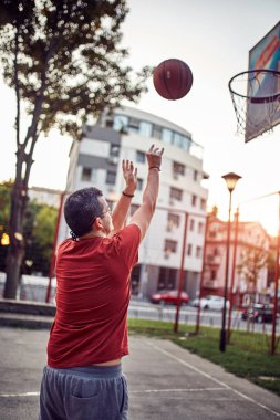Basketbol sahasında atış yapan bir adam.