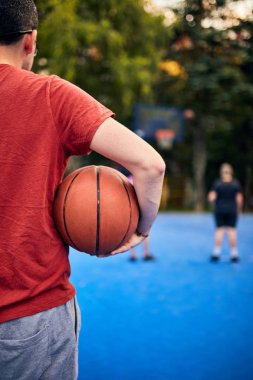 Şehir sahasında basketbol topu tutan adam..