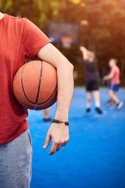 Şehir sahasında basketbol topu tutan adam..