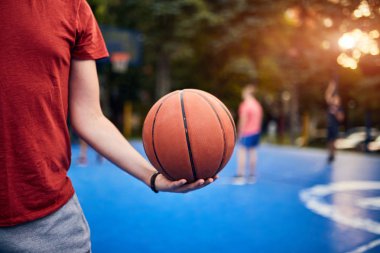 Şehir sahasında basketbol topu tutan adam..
