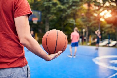 Şehir sahasında basketbol topu tutan adam..