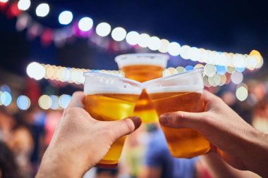 Gece bira içen arkadaşlar. Çantanın içinde odaklanmış olmayan ışıklar var.