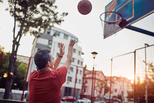 Hombre disparando en una cancha de baloncesto . — Foto de Stock