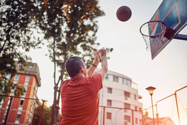 Homem atirando em um campo de basquete . — Fotografia de Stock