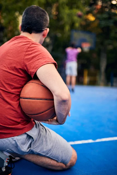 Homem segurando bola de basquete no campo urbano da cidade . — Fotografia de Stock