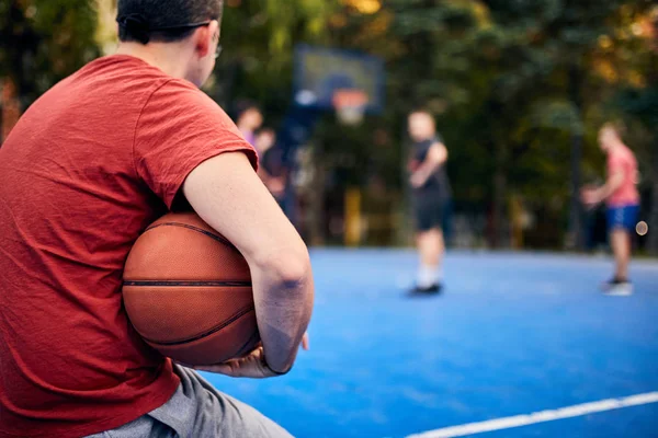 Homem segurando bola de basquete no campo urbano da cidade . — Fotografia de Stock