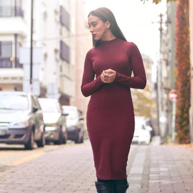 Sokakta yürüyen üzgün genç bir kadın.