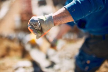 Ağır bir sitede inşaat işçisi sıkı çalışma yapıyor.