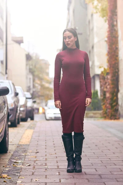 Sokakta yürüyen üzgün genç bir kadın.