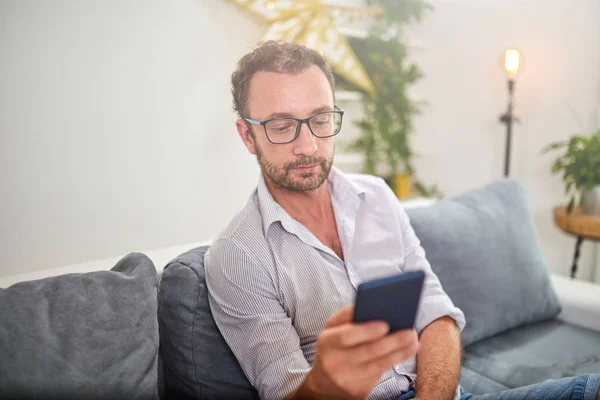 Hombre usando smartphone en la sala de estar . — Foto de Stock