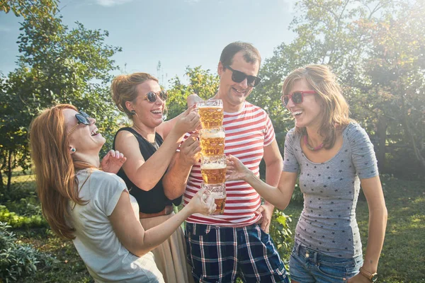 Groep jonge mensen genieten en juichen bier buitenshuis. — Stockfoto