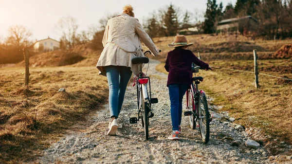 母亲和女儿与自行车在农村. — 图库照片