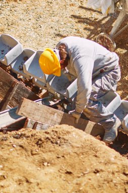 Ağır bir sitede inşaat işçisi sıkı çalışma yapıyor.
