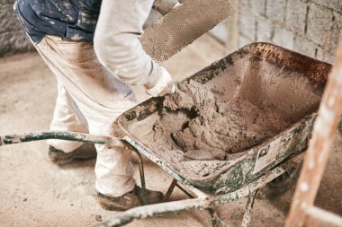 Gerçek inşaat işçisi yeni evin içinde bir duvar yapma.