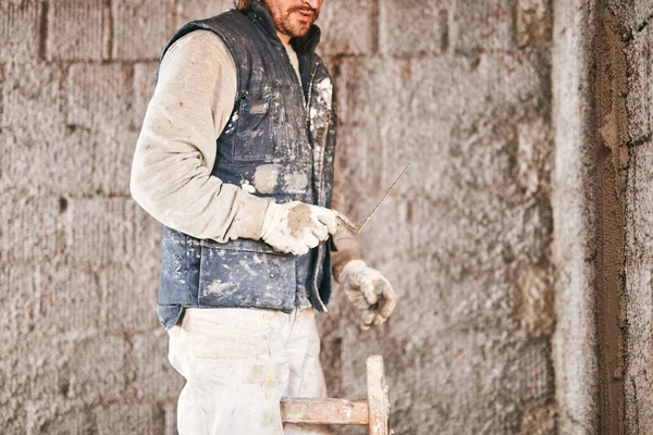 Vrai ouvrier de la construction faisant un mur à l'intérieur de la nouvelle maison . — Photo