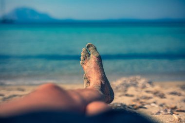 Yalan ve tropikal bir kumsalda zevk adam.