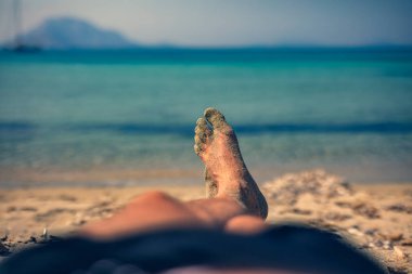 Yalan ve tropikal bir kumsalda zevk adam.