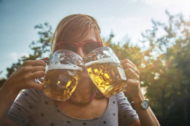 Sevimli kız iki bardak bira açık havada oyun.