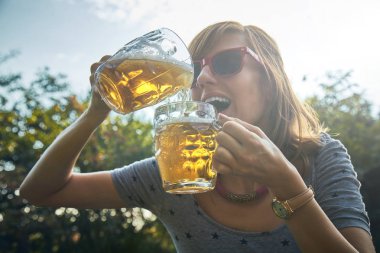 Sevimli kız iki bardak bira açık havada oyun.